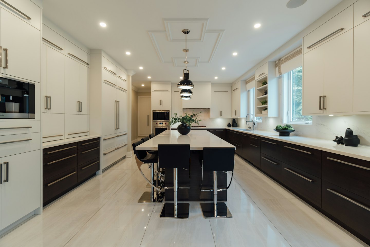 Modern kitchen island with four black bar stools.
